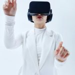 Woman using VR headset, exploring technology in a white setting.